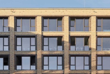 Das filigrane Design der anthrazitfarbenen Aluminiumsysteme fügt sich perfekt in die Industriearchitektur ein.