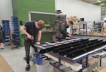 Ausbildung-Maenner in Produktionshalle am Arbeiten